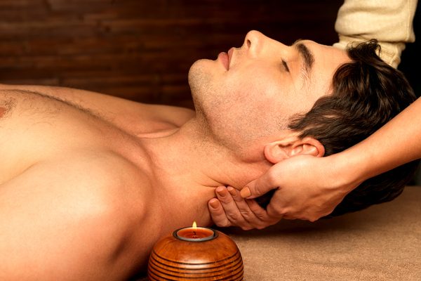 Masseur doing neck massage on man in the spa salon.